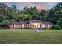 Expansive view of a single-story brick home featuring a large front lawn and mature trees at 598 Maple Branch Rd, Reevesville, SC 29471