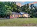 A brick home boasts a wide lawn, mature trees, and driveway at 598 Maple Branch Rd, Reevesville, SC 29471