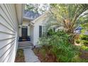 Inviting front entrance with a dark-colored door, blue potted plants, and lush tropical greenery at 642 Bridlewood Ln, Mount Pleasant, SC 29464