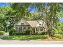 Charming single Gathering home featuring a brick facade, well-manicured lawn, mature trees, and inviting curb appeal at 652 Spinner Cir, Mount Pleasant, SC 29464