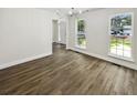 Dining room boasting hardwood floors, a modern chandelier, two large windows, and neutral paint at 702 Spark St, Mount Pleasant, SC 29464