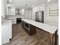 Open kitchen with white cabinets, stainless steel appliances, and a large island with countertop seating at 702 Spark St, Mount Pleasant, SC 29464