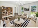 Bright living room featuring hardwood floors, a striped rug, neutral furniture, and natural light at 702 Spark St, Mount Pleasant, SC 29464