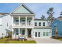 Charming two-story home boasts a light blue exterior, a welcoming front porch, and a second-story balcony at 766 Maynard Ln, Summerville, SC 29486