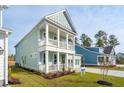 Beautiful two-story home showcases light blue siding, a covered front porch, and a lovely landscaped yard at 766 Maynard Ln, Summerville, SC 29486
