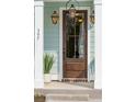 Elegant wood front door with glass panes, complemented by stylish lanterns and a potted succulent at 766 Maynard Ln, Summerville, SC 29486
