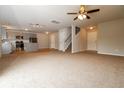 Open-concept living space with neutral walls, ceiling fan and kitchen area at 8285 Little Sydneys Way, North Charleston, SC 29406