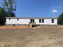 The back of the manufactured home has a wooden porch, windows, and sliding door at 1010 Universal Cir, Saint Stephen, SC 29479