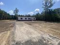 Manufactured home with a large yard and gravel driveway offers ample space at 1010 Universal Cir, Saint Stephen, SC 29479