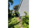 Side view of the home with grey siding, lush landscaping, and a neatly maintained lawn at 120 Townsend Way, Summerville, SC 29483