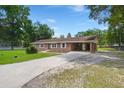 Charming brick ranch-style home with a covered carport and long driveway surrounded by mature trees and well maintained lawn at 122 Lawrence Rd, Moncks Corner, SC 29461