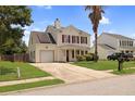 Charming two-story home with vinyl siding, red shutters, front yard landscaping, and solar panels at 136 Blue Jasmine Ln, Summerville, SC 29483