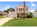 Charming two-story home with vinyl siding, red shutters, front yard landscaping, and solar panels at 136 Blue Jasmine Ln, Summerville, SC 29483