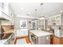 This kitchen features white cabinets, modern appliances, an island with a cooktop, and a wine cooler at 136 Fair Sailing Rd, Mount Pleasant, SC 29466