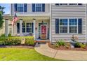 Inviting front porch with an American flag, a welcome sign, and a beautifully landscaped garden area at 180 Willowbend Ln, Summerville, SC 29485