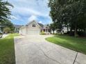 Inviting home with a long driveway, attached garage, and well-manicured front lawn and landscaping at 213 Ashmont Dr, Wando, SC 29492