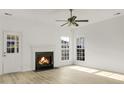 Bright living room features a fireplace, three windows with natural light, a ceiling fan, and wood-look flooring at 3013 Argyll Dr, Summerville, SC 29483
