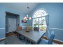 Inviting dining area with a gray washed dining table, large window, neutral walls and stylish chandelier at 309 Hathaway Dr, Goose Creek, SC 29445
