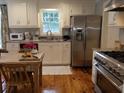 Modern kitchen with stainless steel appliances, white cabinets, granite countertops, and hardwood flooring at 3646 Hilton Dr, Johns Island, SC 29455