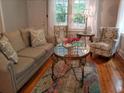 Inviting living room with hardwood floors, neutral colored sofa, wingback chairs, and round glass table at 3646 Hilton Dr, Johns Island, SC 29455