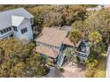 Aerial view of a two-story home surrounded by mature trees and featuring a spacious deck at 504 W Ashley Ave, Folly Beach, SC 29439