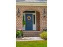 A beautiful blue front door with nice exterior decor, surrounded by brick trim at 525 Yellow Tower Ter, Charleston, SC 29412