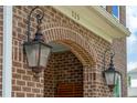 A well lit front porch showing the brick design with two dark lamps, and the house number at 525 Yellow Tower Ter, Charleston, SC 29412