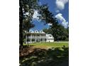 Stately two-story home featuring a white facade, double balconies, a well-maintained lawn, and an attached two-car garage at 5681 Captain Kidd Rd, Hollywood, SC 29449
