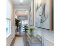 Welcoming entryway showcasing neutral walls, wood floors, modern console table and a glimpse into living spaces at 754 Blue Iris Way, Summerville, SC 29486