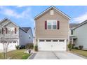 Lovely two-story house with white garage, tasteful landscaping, and appealing architectural details at 9009 Cat Tail Pond Rd, Summerville, SC 29485
