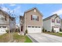 Inviting two-story home with a two-car garage, red front door, and professionally landscaped yard at 9009 Cat Tail Pond Rd, Summerville, SC 29485