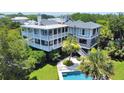 Spacious home exterior featuring a lush backyard, sparkling pool, and a staircase to the upper level at 932 Middle St, Sullivans Island, SC 29482