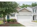 Attractive two-story home featuring a large garage, manicured lawn, and a welcoming entrance at 9815 Seed St, Ladson, SC 29456