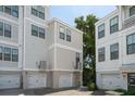 Exterior of three-story townhome featuring multiple garages and neutral-toned siding at 992 Key Colony Ct, Mount Pleasant, SC 29464