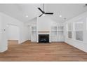 Bright living room boasts fireplace, built-ins, ceiling fan, and hardwood floors at 0 Butterfly Ln, Awendaw, SC 29429