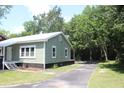 Side view of a charming light green cottage-style home and adjacent paved drive at 103 Ann St, Saint George, SC 29477