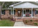 Inviting front porch with brick steps, decorative bench, and a stylish front door with glass detail at 104 Jackson Rd, Ladson, SC 29456
