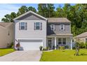 Charming two-story home featuring gray and white siding, a well-maintained lawn, and an attached two-car garage at 108 Rusting Link Rd, Summerville, SC 29483
