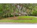 Charming home with lush landscaping, a well-manicured lawn and mature trees with Spanish Moss at 1225 Dennis Blvd, Moncks Corner, SC 29461