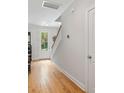 Bright entryway featuring hardwood floors, white walls, and a view of the front door and staircase at 1682 Mermentau St, Mount Pleasant, SC 29466