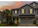 Inviting home with gray exterior, black shutters, a yellow door, and illuminated windows at sunset at 1682 Mermentau St, Mount Pleasant, SC 29466