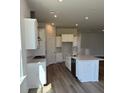 Modern kitchen with white cabinets, stainless steel appliances, and a spacious island at 235 Denham St, Summerville, SC 29486