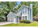 Inviting two-story home with light blue siding, a red front door, and a well-manicured lawn at 2773 Forest Dew Ct, Charleston, SC 29414