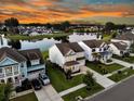 A serene community view with lush landscaping surrounding homes by a tranquil lake reflects the sunset, creating a captivating vista at 292 Calm Water Way, Summerville, SC 29486