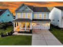 Charming two-story home featuring a welcoming front porch, well-manicured lawn, and a spacious two-car garage at 292 Calm Water Way, Summerville, SC 29486