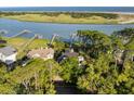 Stunning aerial view of a home with private docks on the water, surrounded by lush trees and greenery at 3121 Marshgate Dr, Seabrook Island, SC 29455