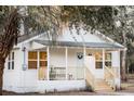 Charming white cottage with a welcoming front porch and lush green surroundings at 3480 Johan Blvd, Johns Island, SC 29455