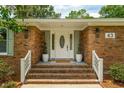 Inviting front entrance featuring a classic white door, elegant plants, and brick steps at 43 Heathwood Dr, Charleston, SC 29407