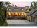 Inviting two-story home with a charming front porch, well-lit windows, and manicured landscaping at 627 Barbados Dr, Charleston, SC 29492