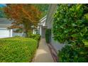 A paved walkway leading to the front entrance, lined with manicured bushes and vibrant foliage at 9175 Spring Branch Ct, North Charleston, SC 29406